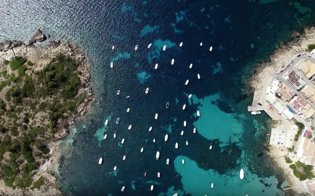 Vista aérea de la cala de Sant Elm con barcos fondeados